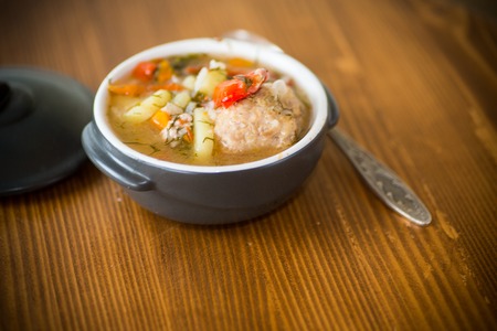 vegetable soup with meatballs and pepper in a plate on the tableの写真素材