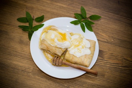 sweet pancakes with cottage cheese, sour cream and honey in a plateの写真素材