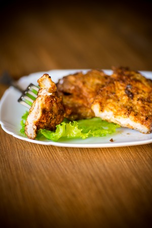 pork fillet chop fried in batter, in a plateの写真素材