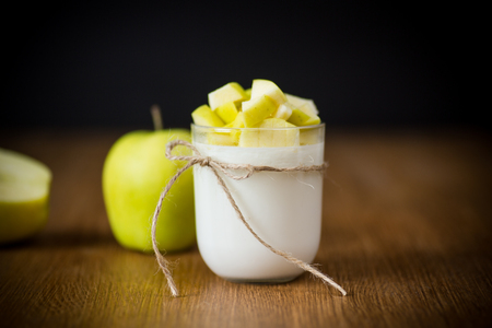 homemade yogurt with ripe apples on wooden tableの写真素材