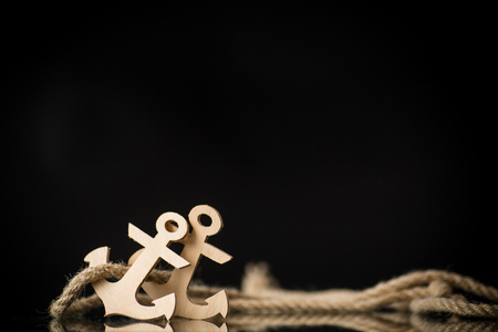 wooden decorative anchor on a black backgroundの写真素材