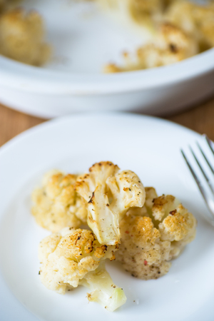 baked cauliflower with spices in ceramic formの写真素材
