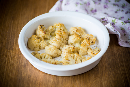 baked cauliflower with spices in ceramic formの写真素材