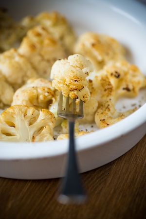 baked cauliflower with spices in ceramic formの写真素材