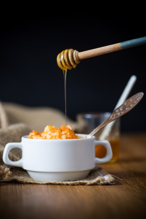 sweet boiled pumpkin porridge with rice in a plate on a woodenの写真素材