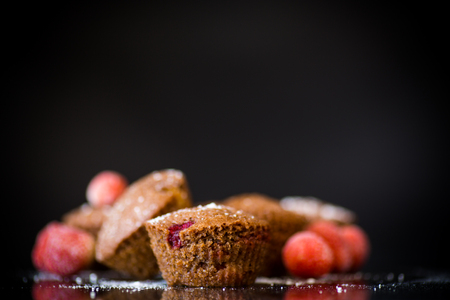 fresh sweet muffins with berries inside on blackの写真素材