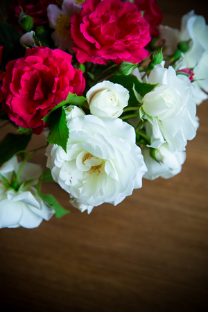 bouquet of beautiful red and white roses on a wooden tableの写真素材