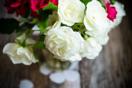 bouquet of beautiful red and white roses on a wooden tableの写真素材
