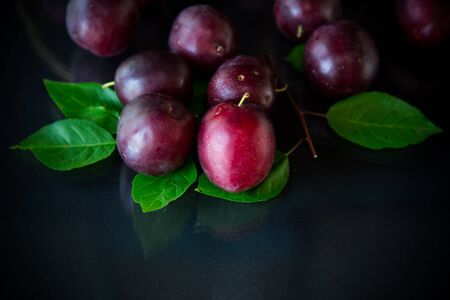organic red ripe cherry plum isolated on blackの写真素材