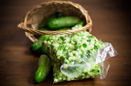 Diced cucumbers in a vacuum bag on a wooden tableの写真素材