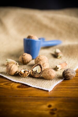 organic natural walnuts and nut cracker on a wooden tableの写真素材