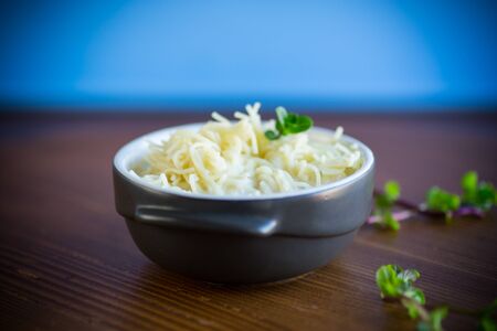 sweet boiled vermicelli with milk in a ceramic bowl on a wooden tableの写真素材
