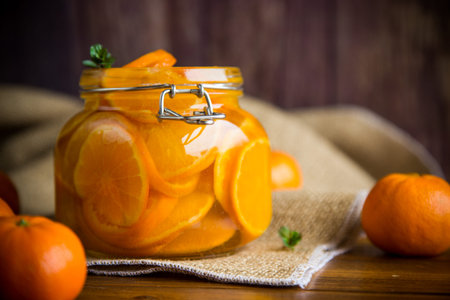 sweet tangerine jam in a glass jar on a wooden tableの写真素材