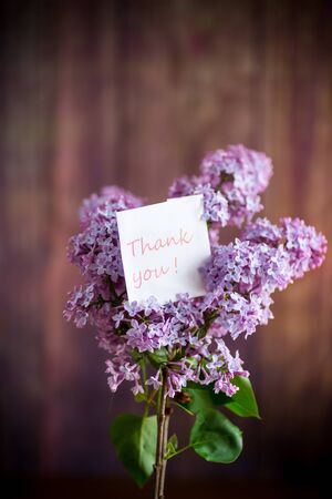 bouquet of beautiful spring lilac flowers on a wooden backgroundの写真素材
