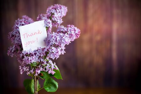 bouquet of beautiful spring lilac flowers on a wooden backgroundの写真素材