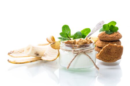 sweet homemade yogurt with fresh bananas and slices of oatmeal cookies in a glass jarの写真素材