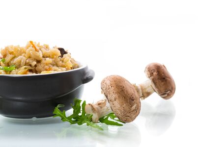vegetarian cooked rice with mushrooms in a ceramic bowl isolated on white backgroundの写真素材