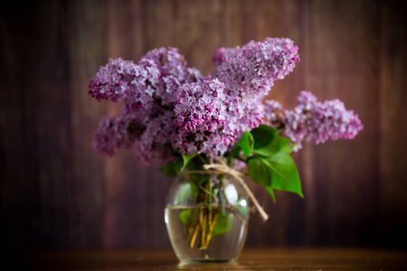 bouquet of beautiful spring flowers of lilac on the tableの写真素材