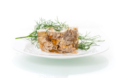 slice of chilled jellied meat in a plate on a white background