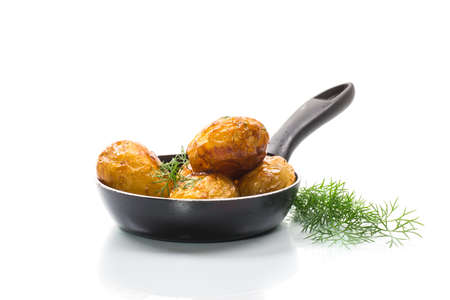 whole fried young potatoes in a pan isolated on white backgroundの写真素材
