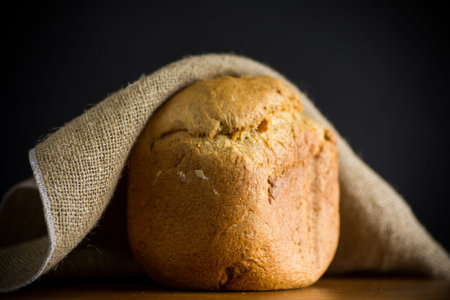 baked homemade bread from a bread machine on a black background