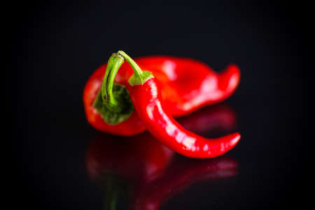 two hot spicy cayenne peppers on black backgroundの写真素材