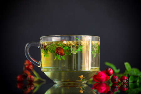 hot herbal tea from various herbs in glass cup isolated on black backgroundの写真素材