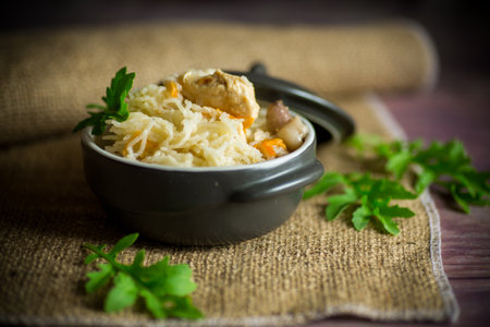 light boiled rice with vegetables and meat in a ceramic bowl on a wooden tableの写真素材