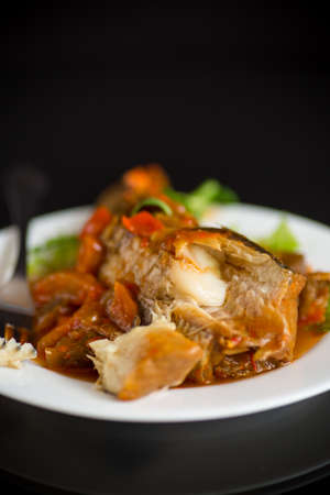 whole fish hake stewed with carrots, beets, peppers and other vegetables.の写真素材