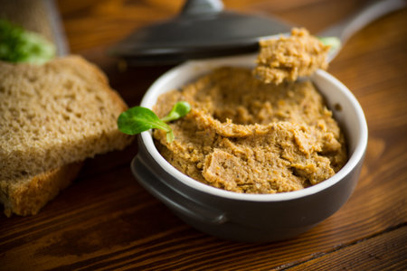 cooked homemade meat pate in a ceramic bowl on a wooden table