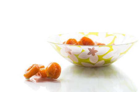 sweet delicious dried apricots in a bowl isolated on white backgroundの写真素材