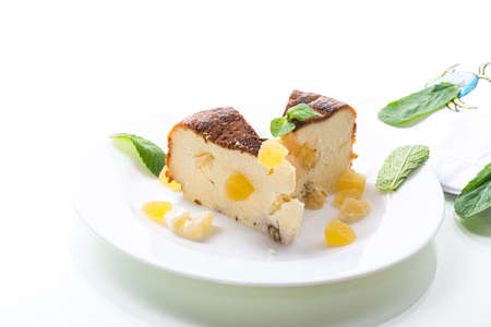 sweet baked cottage cheese casserole with nuts and candied fruits isolated on white backgroundの写真素材