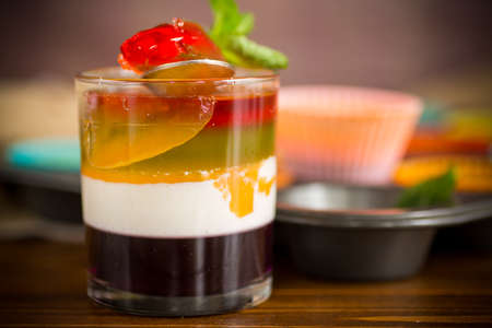 lot of colored sweet fruit jelly in a glass on a wooden tableの写真素材