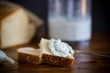 homemade salted curd spread with herbs and garlic, for a sandwich.の写真素材