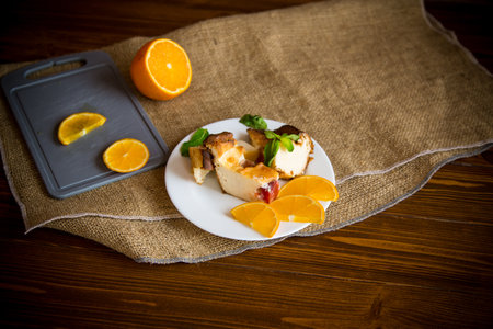 Sweet curd casserole with fruits in a plate on a wooden tableの写真素材
