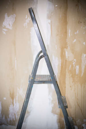 old stepladder on the background of plastered walls before renovationの写真素材