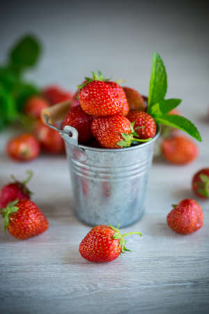 harvest of red ripe natural strawberries on a wooden tableの写真素材