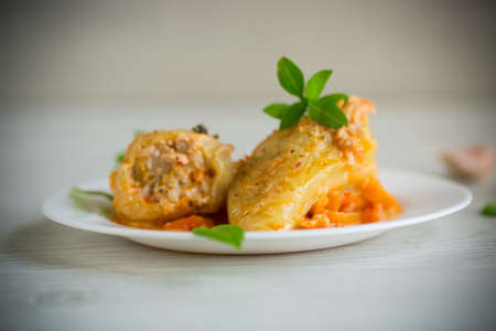 stewed in gravy stuffed peppers in a plate on a wooden tableの写真素材