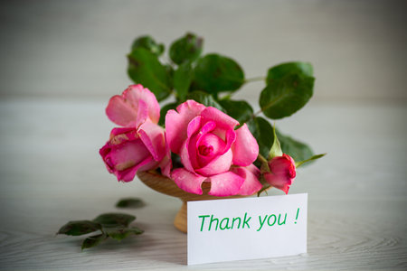 pink beautiful summer roses on wooden tableの写真素材