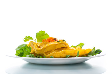 Egg omelet stuffed with tomato and greens fried in the form of waffles, isolated on white background