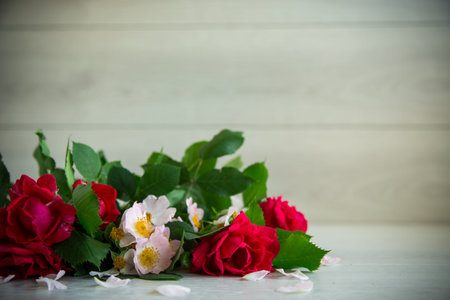 beautiful background of many red roses on a light wooden