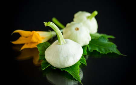 fresh organic squash with flowers and foliage isolated on black backgroundの写真素材