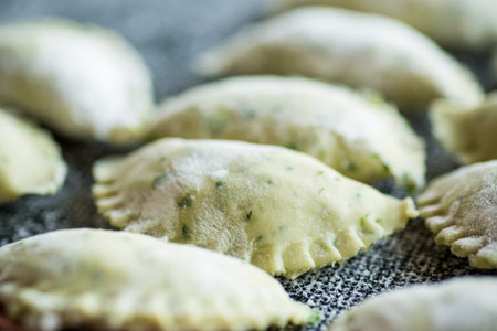 Raw dumplings from dough with herbs, dill and parsley. Raw dumplings close-up.