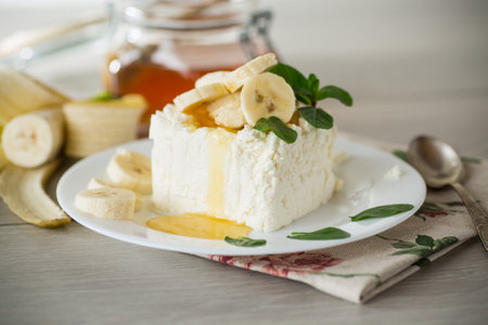 Portion of homemade milk curd with banana slices and honeyの写真素材