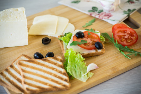 fried toasts with mozzarella, lettuce and tomatoes with herbsの写真素材