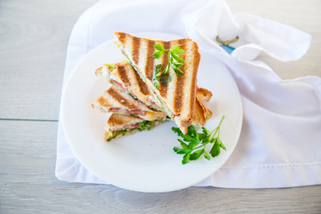 fried toasts stuffed with sausage, cheese and greens inside, in a bowl on the table..の写真素材