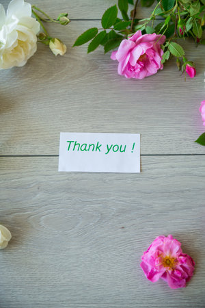 Floral background of pink and white roses on a light wooden tableの写真素材