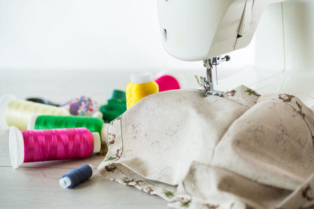 Sewing machine with fabric and threads for sewing, close-up. The working process. Part of a sewing...