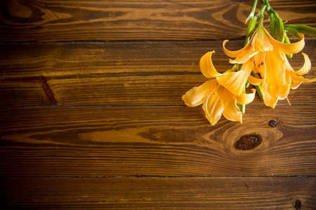 bouquet of beautiful yellow lilies on a dark wooden tableの写真素材