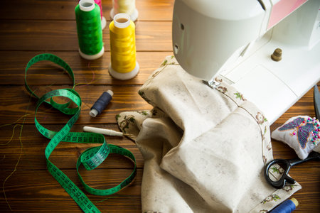 Sewing machine with fabric and threads for sewing, close-up. The working process